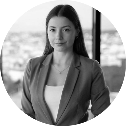 A woman in a suit standing next to a window.